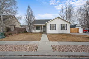 Ranch-style home with a porch and fence