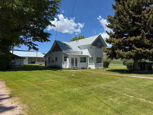 View of front of house featuring french doors, a front lawn, and a metal roof