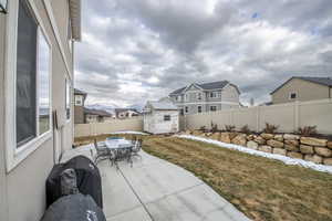 View of patio with a storage shed, outdoor dining space, a residential view, a fenced backyard, and an outdoor structure