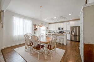 Dining space with a chandelier, dark wood-type flooring, baseboards, and recessed lighting