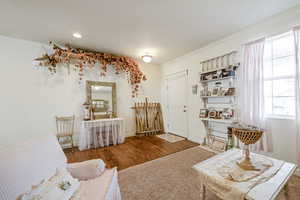 Living area featuring dark wood-style floors, baseboards, and crown molding