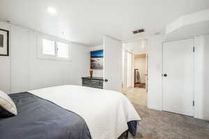 Bedroom with light carpet and visible vents