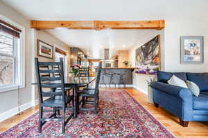 Dining space featuring beam ceiling, light wood-type flooring, and a wealth of natural light