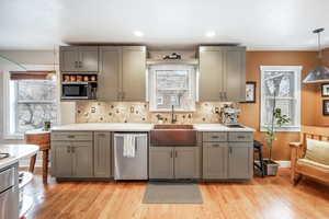 Kitchen featuring stainless steel appliances, pendant lighting, light countertops, and a sink