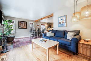 Living area with wood finished floors, visible vents, and baseboards