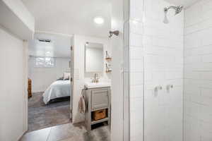 Ensuite bathroom featuring visible vents, connected bathroom, tile patterned floors, a tile shower, and vanity