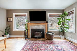 Unfurnished living room featuring a healthy amount of sunlight, light wood finished floors, baseboards, and visible vents