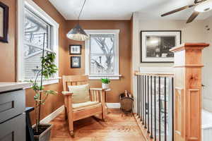 Sitting room with baseboards, a healthy amount of sunlight, and light wood finished floors