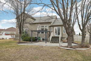 Back of property with a lawn, roof with shingles, fence, a pergola, and stucco siding