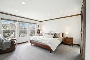 Bedroom with recessed lighting, light carpet, crown molding, and baseboards