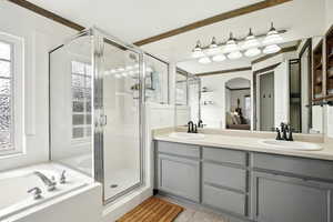 Ensuite bathroom with connected bathroom, tile patterned flooring, a sink, and a stall shower