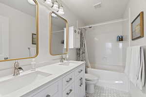 Full bathroom with shower / bath combo with shower curtain, visible vents, a sink, and tile patterned floors