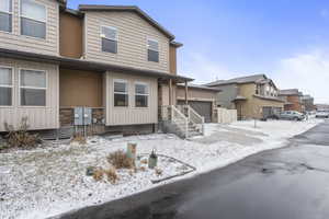 Townhome / multi-family property with driveway, an attached garage, and a residential view