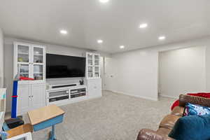 Living area with recessed lighting, visible vents, baseboards, and light colored carpet