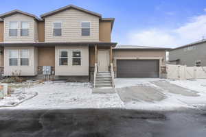 View of front of home with a gate, fence, and an attached garage