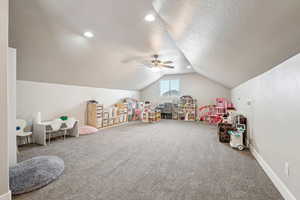 Recreation room featuring carpet floors, lofted ceiling, recessed lighting, a textured ceiling, and baseboards