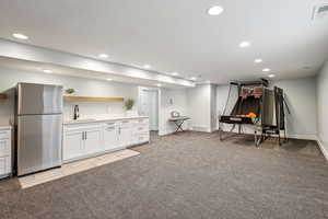 Interior space with recessed lighting, a sink, visible vents, and light colored carpet