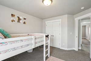 Carpeted bedroom with a closet and baseboards