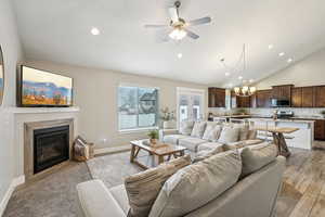 Living area with baseboards, light wood finished floors, a fireplace, and recessed lighting