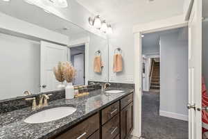 Full bath with visible vents, a sink, baseboards, and double vanity