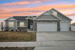 View of front of house featuring board and batten siding, driveway, and a garage