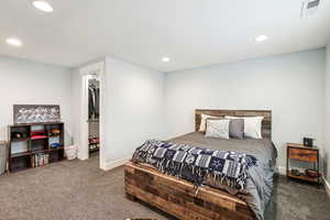 Bedroom featuring recessed lighting, visible vents, dark carpet, a spacious closet, and baseboards