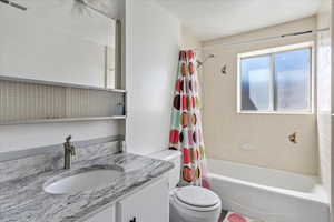 Full bath with shower / tub combo, visible vents, vanity, and toilet