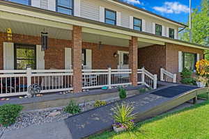 View of front of house with brick siding and a porch