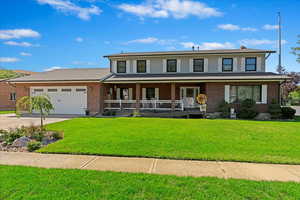 View of front of property featuring a garage, covered porch, a front lawn, and concrete driveway