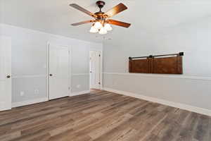 Spare room featuring ceiling fan, baseboards, and wood finished floors