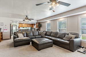 Living area featuring a textured ceiling and light colored carpet