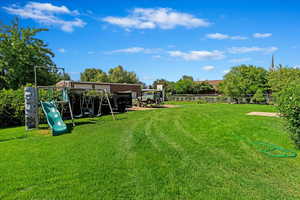 View of yard featuring a playground and fence