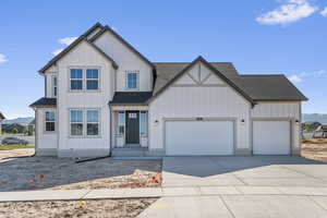 View of front of property with a garage, roof with shingles, driveway, board and batten siding, and a mountain view