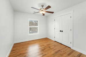 Unfurnished bedroom with a closet, visible vents, light wood-style flooring, ceiling fan, and baseboards