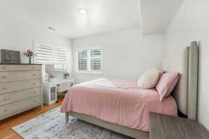 Bedroom with light wood-style flooring and visible vents