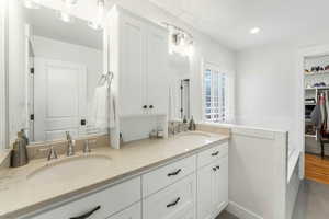 Full bath featuring recessed lighting, a sink, a spacious closet, and double vanity