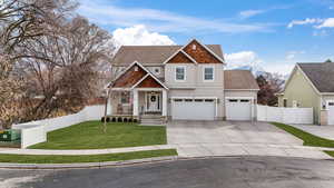 View of front of house with concrete driveway, roof with shingles, fence, a mountain view, and a front lawn