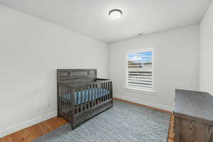 Bedroom featuring wood finished floors, visible vents, and baseboards