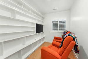 Living area with light wood finished floors, baseboards, and visible vents