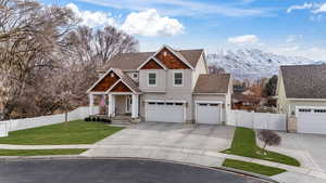 View of front of home featuring driveway, fence, a mountain view, and a front yard