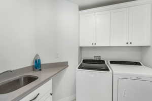 Clothes washing area with cabinet space, washing machine and dryer, and a sink