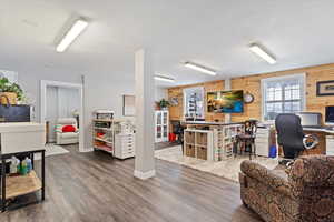 Living room featuring wood walls, wood finished floors, and baseboards