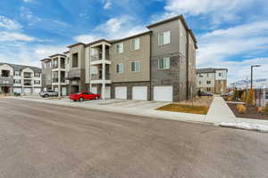 View of property with a garage, driveway, and a residential view