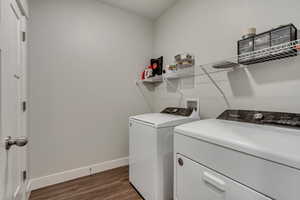 Washroom featuring laundry area, baseboards, dark wood finished floors, and washer and dryer