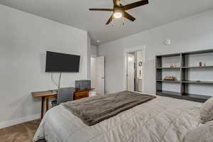 Bedroom with carpet, baseboards, ceiling fan, and connected bathroom