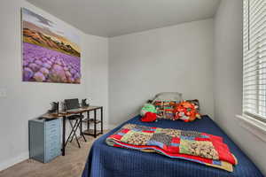 Bedroom with light colored carpet and baseboards