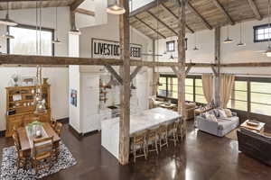 Living area with ceiling fan, high vaulted ceiling, beam ceiling, and wood ceiling