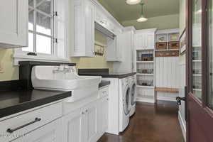 Laundry area featuring independent washer and dryer, a sink, and cabinet space