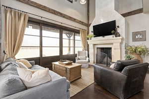 Living room with a towering ceiling, concrete floors, and a fireplace