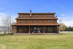 Rear view of property featuring metal roof, a yard, french doors, and fence